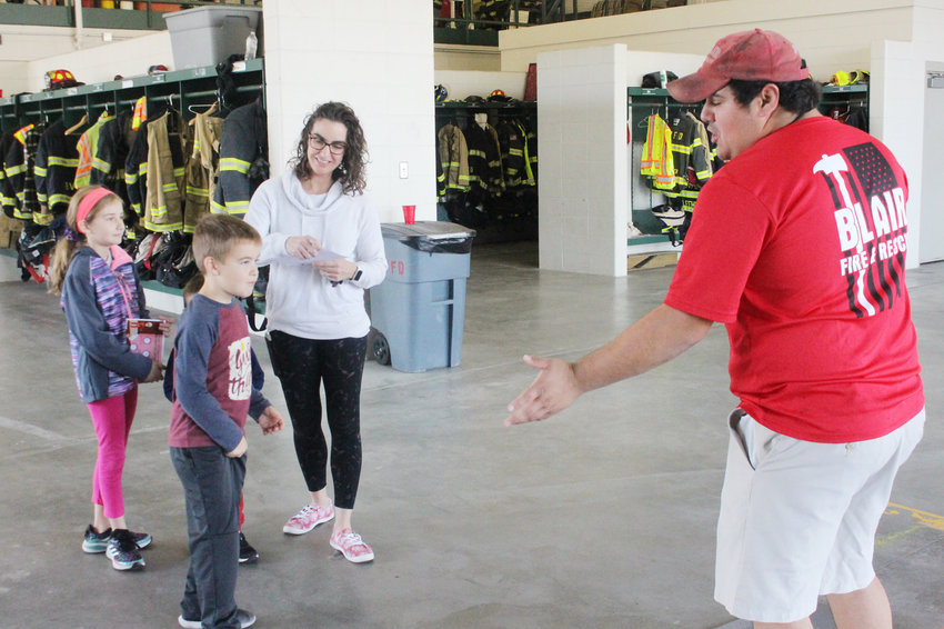 Blair firefighter Anthony Borders talks to a group of children about the importance of stop, drop and roll Saturday during a fire prevention open house at the Blair North Fire Station.