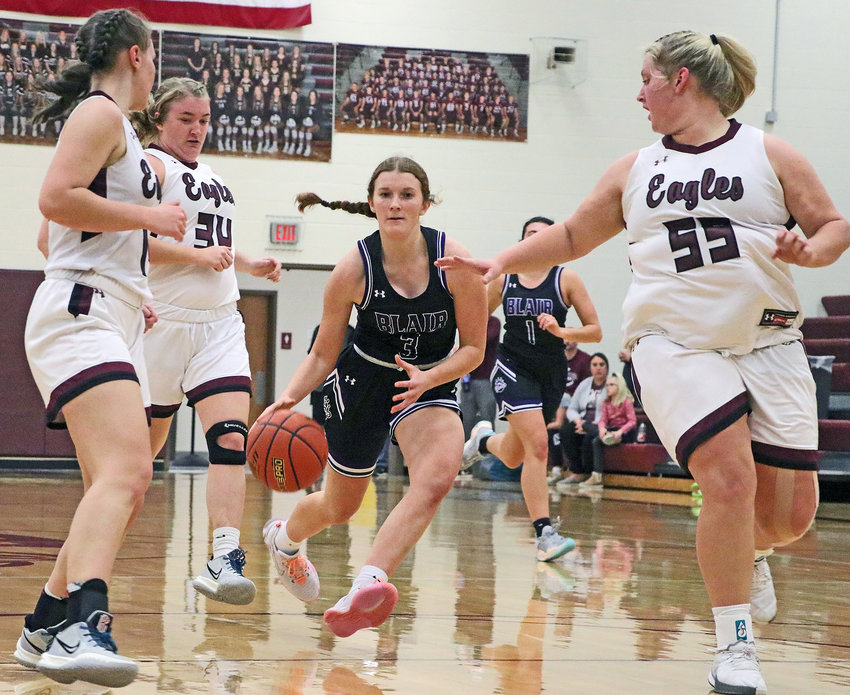 Blair junior Kaitlyn Johnson, middle, drives to the basket between Eagles Stella Lewis, from left, Cassidy Arp and Hailey Brenn on Monday at Arlington High School.