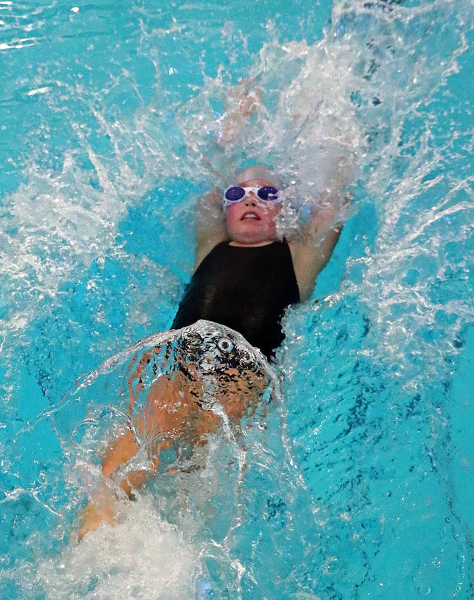 Isabel Chrans, 8, of the Blair Family YMCA Swim Team competes in the 50-yard backstroke Saturday during the Brent Olson Memorial Swim Meet.