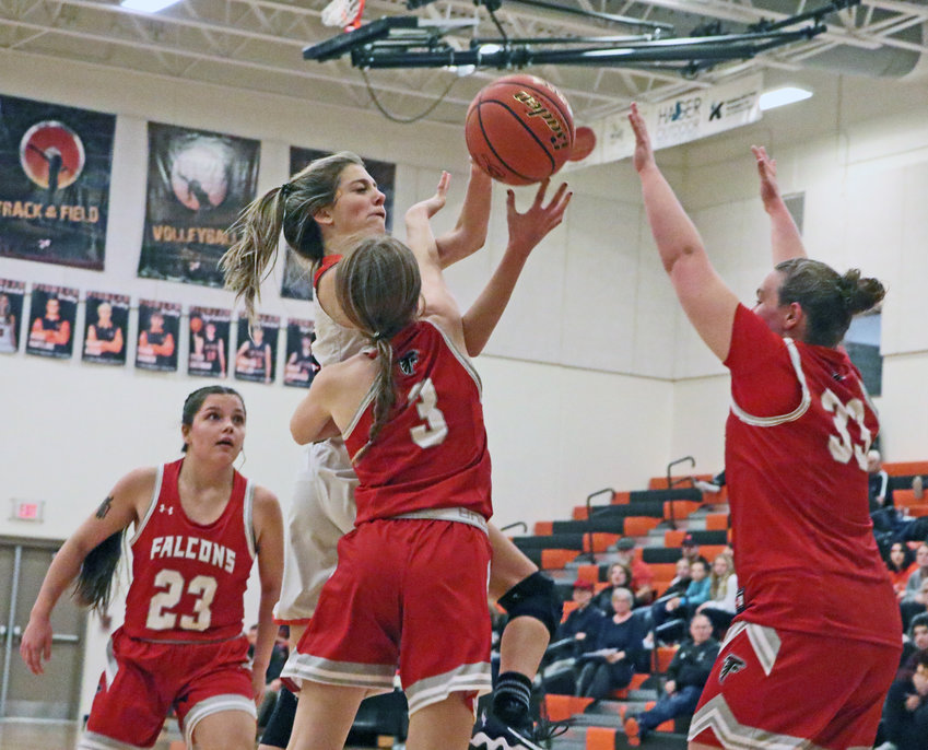 Pioneers senior Tess Skelton, middle, is fouled by No. 3, Olivia Malousek, of Douglas County West on Thursday at Fort Calhoun High School.