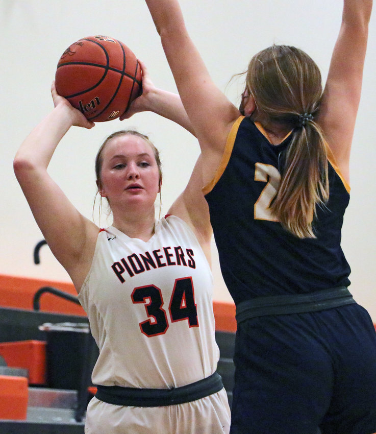 Pioneers sophomore Raegen Wells, left, passes the ball in around Brownell-Talbot's Briley George on Tuesday at Fort Calhoun High School.
