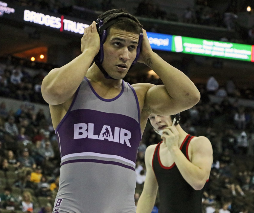 Blair 152-pounder Yoan Camejo adjusts his headgear Thursday during a semifinals victory in Omaha.
