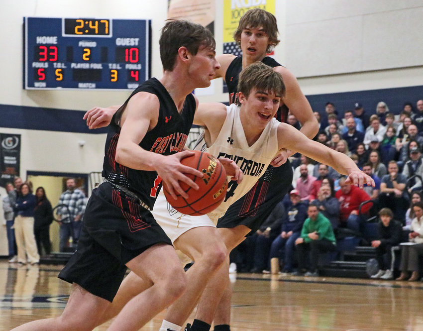 Fort Calhoun senior Owen Newbold, left, dribbles as the Mustangs' Zac Kulus chases around a screen by Wyatt Appel on Thursday at Omaha Concordia.