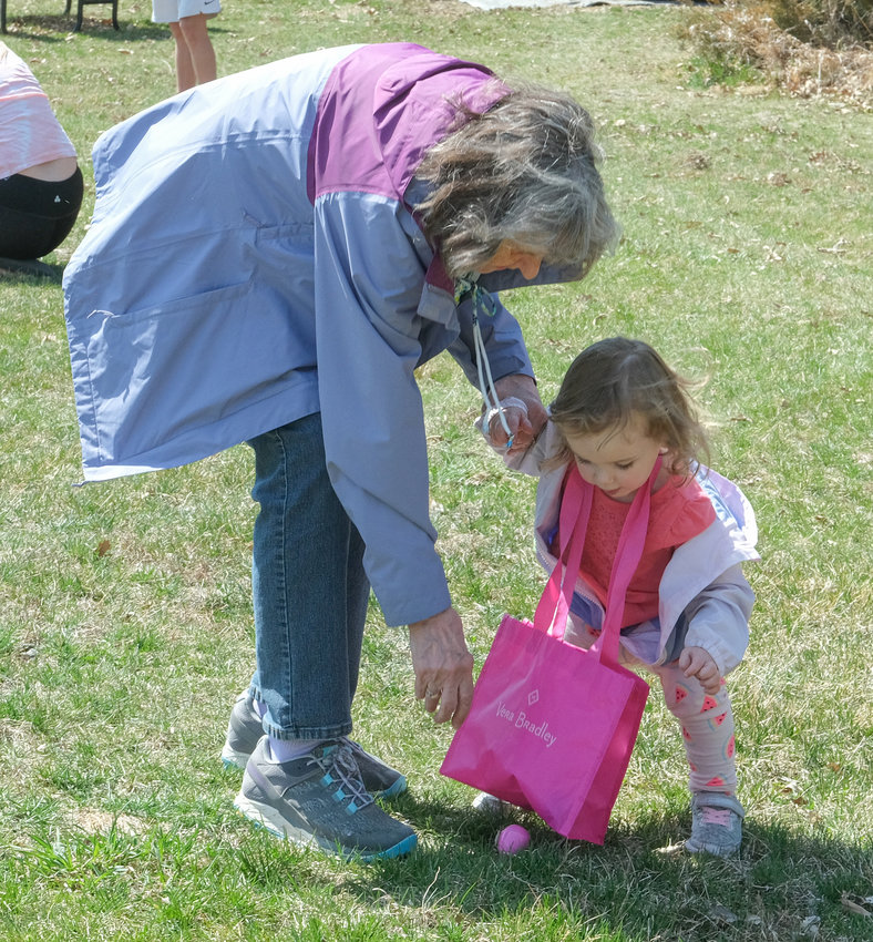 Toddler Kinzie Kemp, with grandmother Vicki Kemp, reaches for an egg at the Camp Fontanelle Easter Egg Hunt April 10.