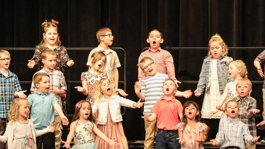 North Primary School first graders looks to catch rain drops during North and South Elementaries' Spring Sing April 7.