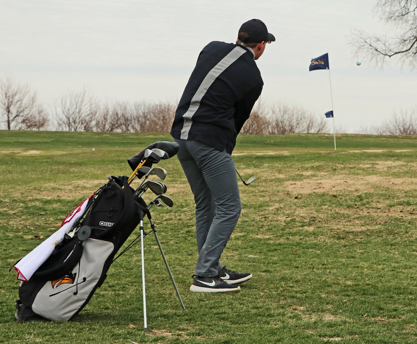 Fort Calhoun senior Tyler Eastman chips onto the green Tuesday at River Wilds Golf Club.