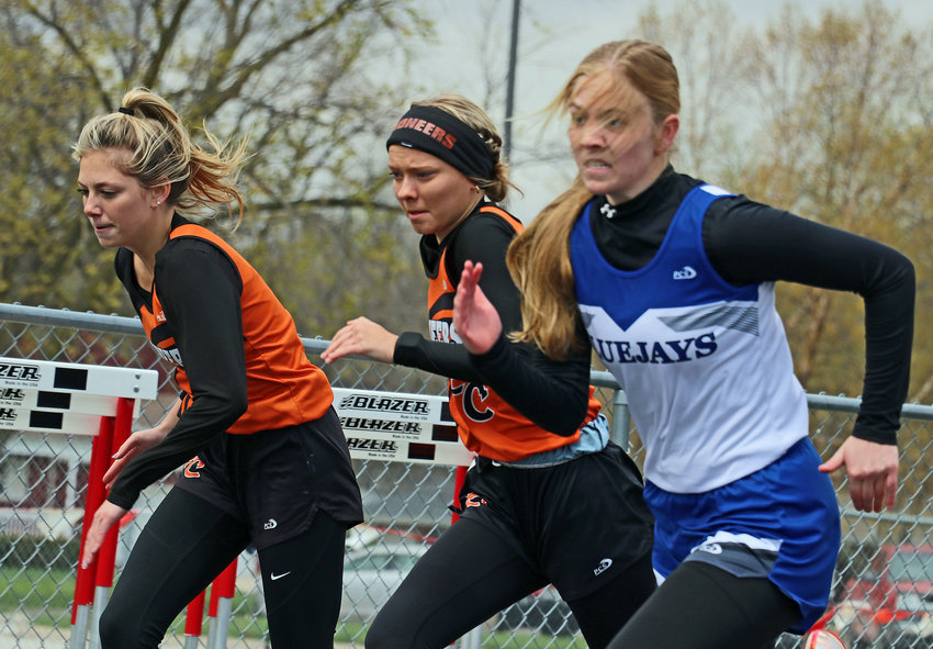 Fort Calhoun's Tess Skelton, left, and Angel Nelson, middle, race an Ashland-Greenwood Bluejay on Tuesday at Yutan High School.