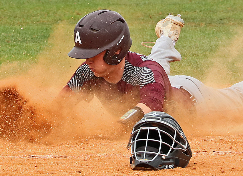 Arlington senior Isaac Foust slides and scores Friday during the Class B District 1 Tournament in Waverly.