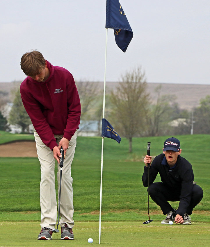 Arlington's Eddie Rosenthal, left, sinks his putt as Fort Calhoun's Owen Newbold eyes his birdie attempt Friday during the Nebraska Capitol Conference Tournament at River Wilds Golf Club. Both players had top-10 days.