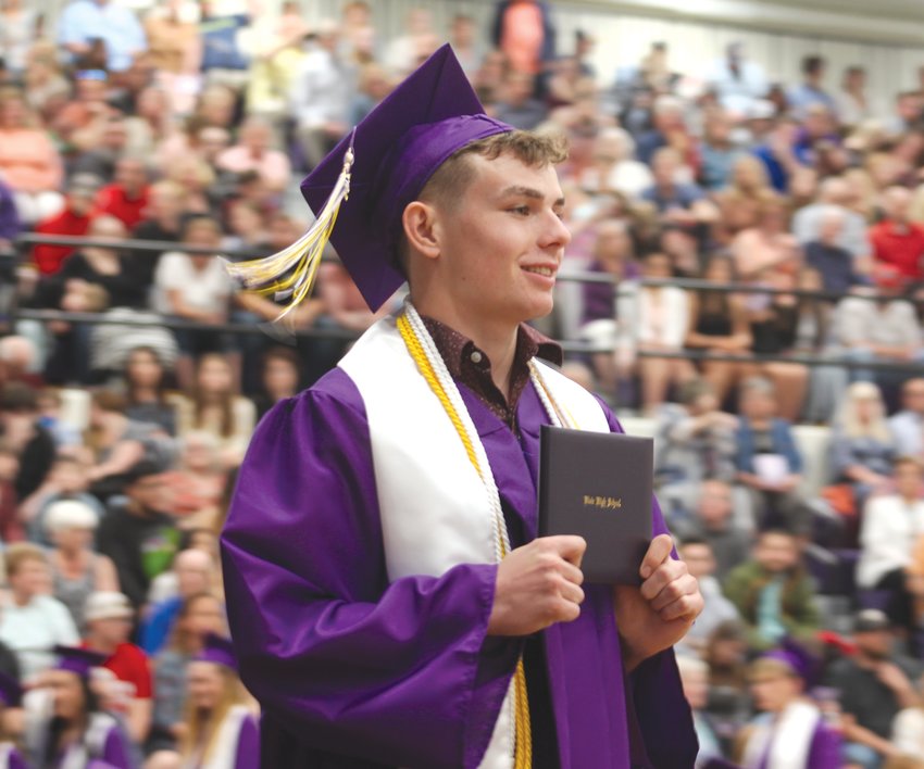Kip Tupa holds up his diploma for family and friends to see.