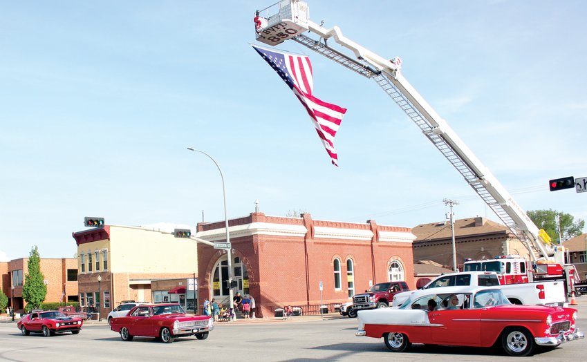 Cars pass under a large United States flag, flown from a Blair Volunteer Fire Department rig, at the first Blair Cruise Night of the year May 14.