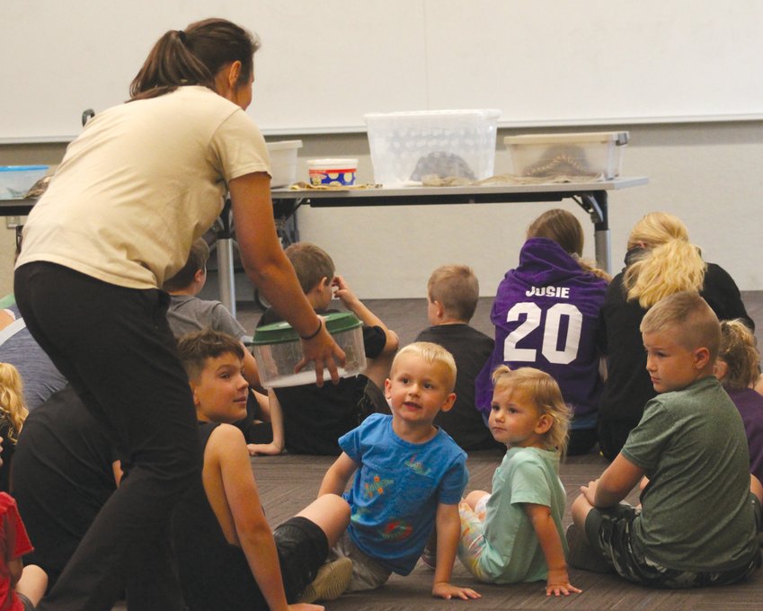 Papio-Missouri River Natural Resources District natural resource educator Kaylyn Kelley shows children a couple of tree frogs on June 7.
