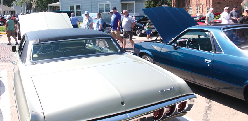 Car show goers stop and look at a couple of classics on June 11.