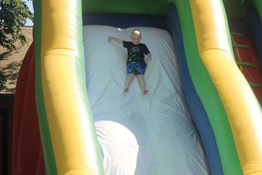 Conlan Bailey, 3, quickly slides down an inflatable slide Sunday during Reach Church's Family Night at Lions Park during Gateway to the West Days.
