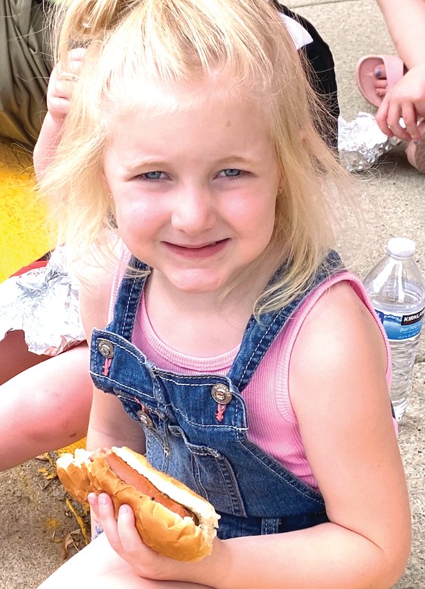 Georgia McCoy enjoys eating a free hot dog from NP Dodge as part of Gateway to the West Days Friday.