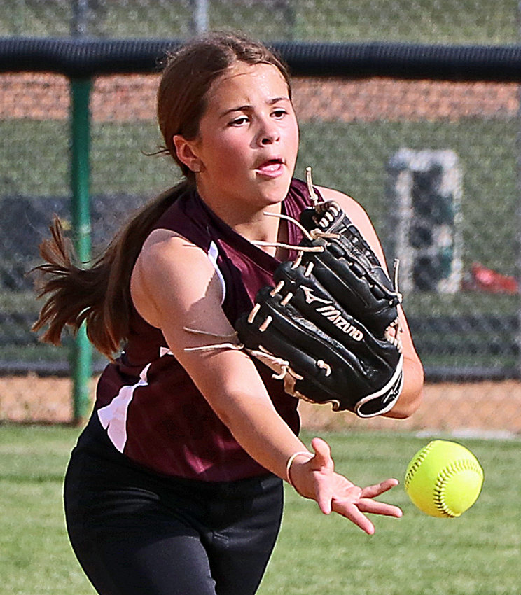 Finley Timm of the 12U Arlington softball team tosses the ball to second base for an out June 10 at the Blair Youth Sports Complex.