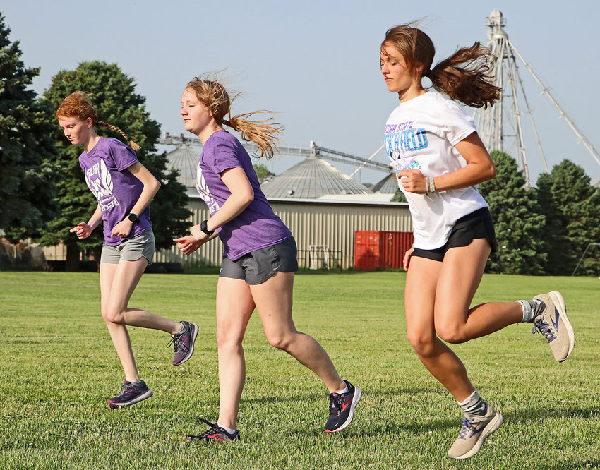 Soon-to-be seniors Paige Dykstra, from left, Chloe Schrick and Hailey Amandus warmup before a run Tuesday at Blair High School.