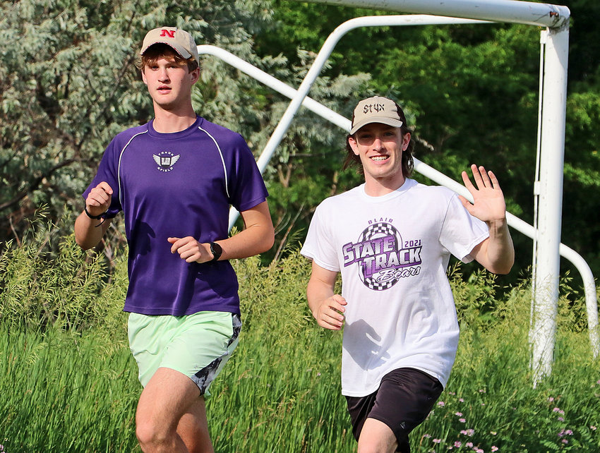 Zac Keeling, right, waves to the camera alongside Caleb Funk on Tuesday's run at Otte Blair Middle School.