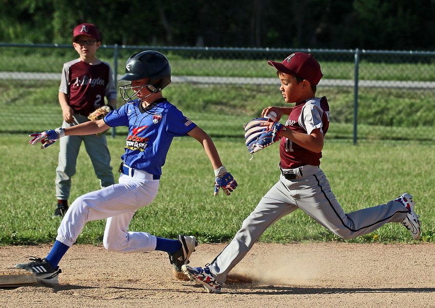 Arlington age 8 and younger second baseman Dominic Misfeldt, right, chases an opposing base runner to the bag June 2 at the Two Rivers Sports Complex. Arlington Youth Baseball's home schedule is coming to a close this week after starting games in April.