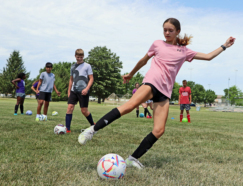 Alexys Wickwire, 13, reaches to kick the ball Tuesday during an afternoon session of the Paul Cox Soccer Camp at the Blair Youth Sports Complex.