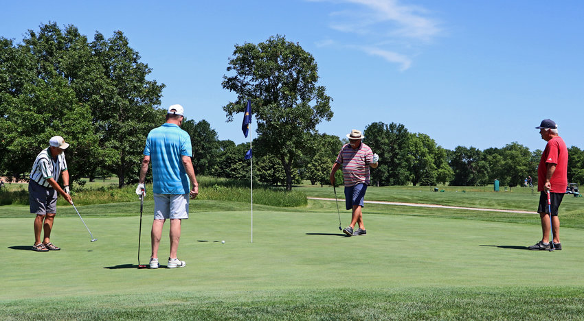 Jeff Christiansen, from left, Brad Taylor, Cary Going and Marshall Nelson play the ninth green Wednesday afternoon during league play at River Wilds Golf Club.