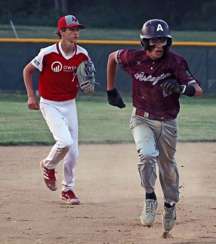Arlington Junior Legion base runner Colton Willmott, right, races from second to third base Monday at the Washington County Fairgrounds.
