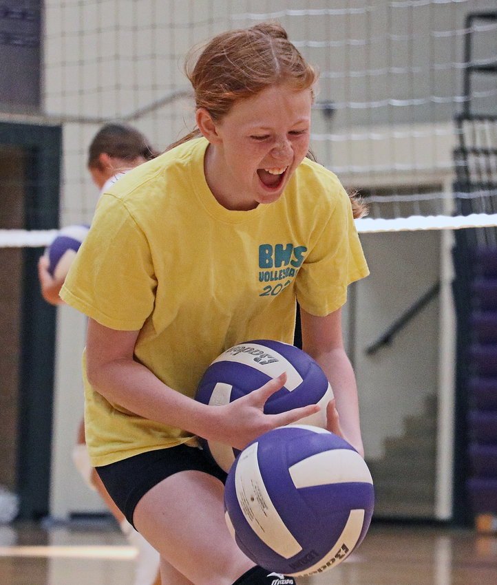 Daphne Barondeau laughs as she drops volleyballs during a relay race Tuesday at Blair High School.