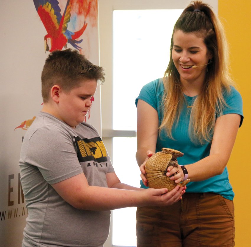 Jillian Lenz of Wildlife Encounter surprises Beckham Hiles with an armadillo named Tater Tot at the Blair Public Library and Technology Center on June 28.