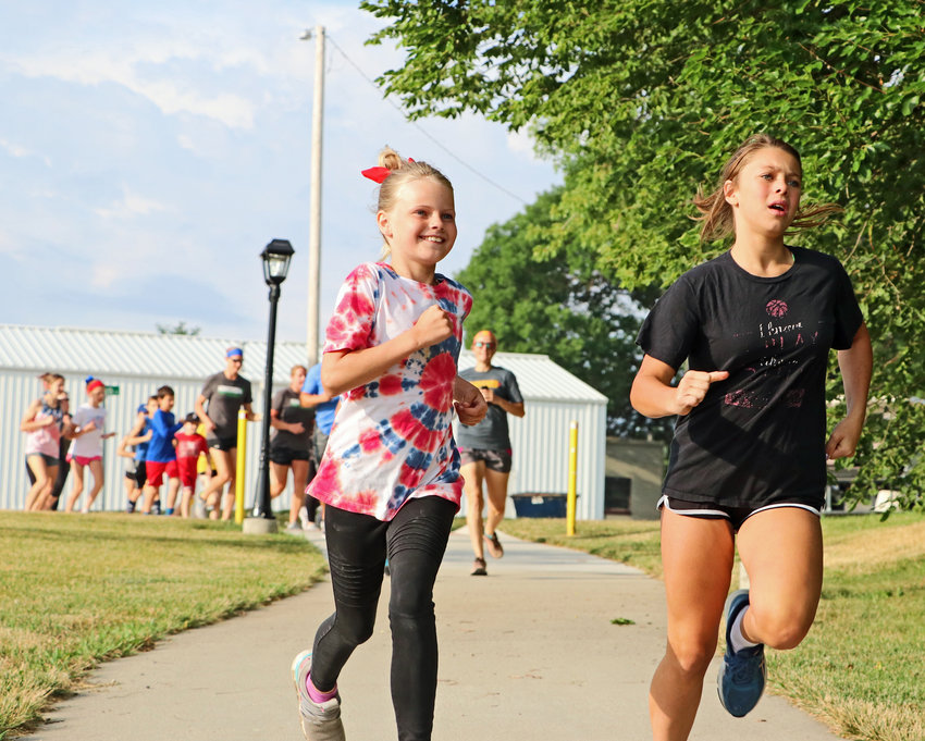 Gemma Fullner, 10, left, and Sianna Fehlhaver, 11, run Saturday morning during the Arlington Summer Sizzle celebration.