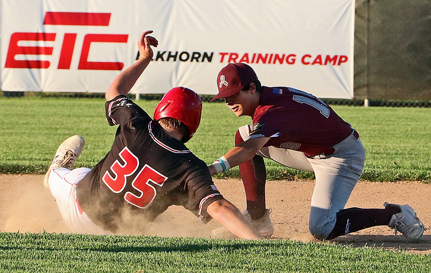 Arlington Junior Legion infielder Tyler Hawley, right, attempts to tag out a Elkhorn Training Camp Knight at second base Friday at Elkhorn Mount Michael.