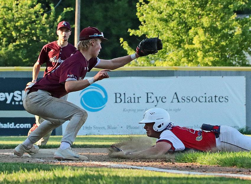Arlington Senior Legion third-baseman Jack Bang, front left, nabs the ball and reaches to tag Blair's Dylan Swanson on Monday at Vets Field. The Post 71 Eagles' Wes Martens, back left, runs up from left field to lend support.