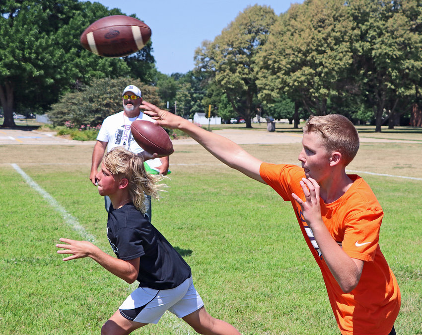 Landry Larsen, 12, left, and Isaak Schultz, 12, compete in front of coach Bryan Soukup on Tuesday during the Blair High School Quarterback Camp. The two-day session was the second of four football camps between July 14 and July 28 in Blair. Linemen camped July 14-15 before QBs Monday and Tuesday. Today's Youth Camp started Thursday, while the Middle and High School camp is next week Monday through July 28.