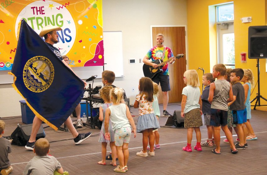 String Bean member Randy shows children the Nebraska flag during a song about the state's history.