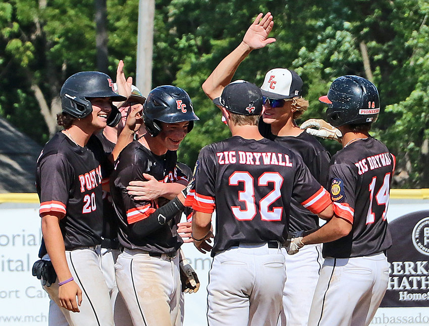 Fort Calhoun Senior Legion batter Sam Genoways, second from left, celebrates walk-off hit Saturday during the Class B Area 3 Tournament at Vets Field. The Pioneers came back from down five runs to beat Wahoo and extend their season.