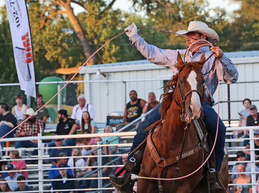 Mitch Barney of Blair completes a successful team-roping run with partner Lakota Elkins of Ericson on Saturday at the Washington County Fairgrounds.
