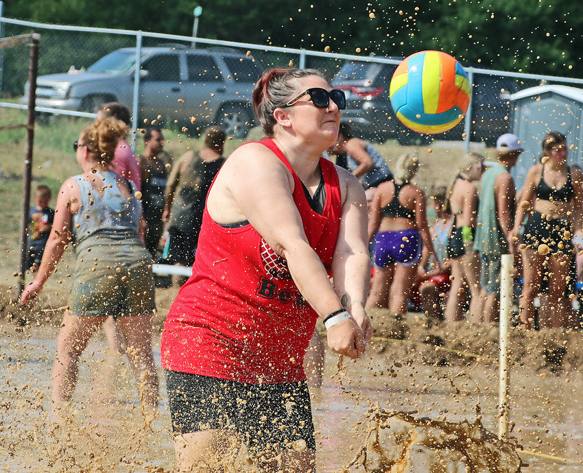 Jamie Culver of North Bend makes a play on the ball amid the muddy chaos Sunday during the Washington County Fair Mud Volleyball Tournament in Arlington. Six mud pitts hosted six games all morning during the event.