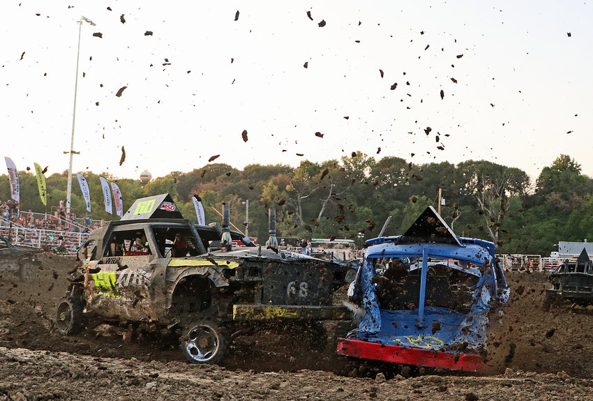 Kenny Rosno, left, and his fellow demolition derby drivers spray dirt clods into the air Aug. 3 at the Washington County Fairgrounds.