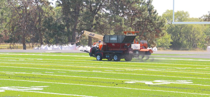 Rubber infill is placed on the new surface at Krantz Field.