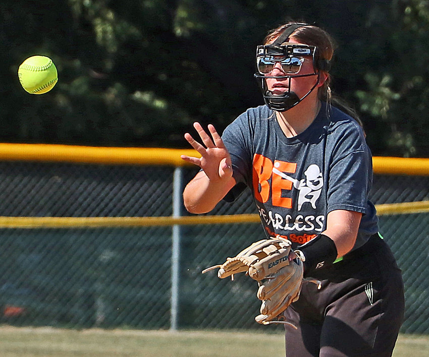 Lucie Larsen flips the ball to a teammate Aug. 10 during infield drills in Fort Calhoun.
