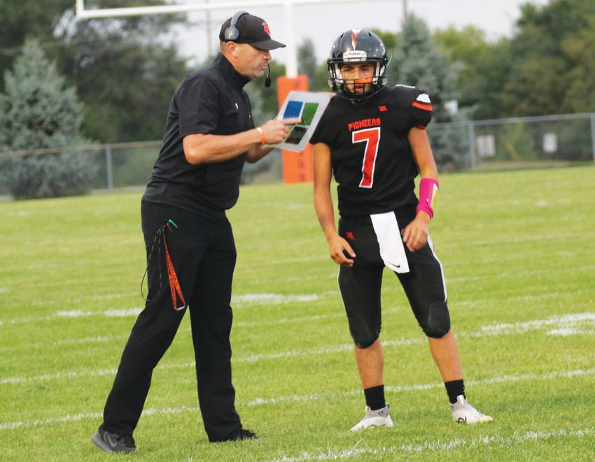 Head coach Adolph Shepardson gives the play call to quarterback Austin Welchert.