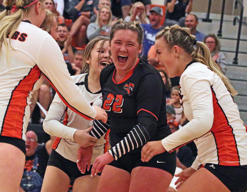 Pioneers junior Mollie Dierks (22) celebrates a point with Ruby Garmong, left, and Tilden Nottlemann, right, during a first-set victory against Raymond Central on Thursday. Fort Calhoun lost the home match, 3-1.