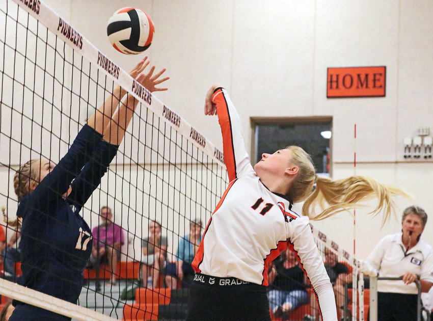 Pioneers senior Olivia Quinlan, right, taps the ball back over her shoulder and Raymond Central's Alliana Miller on Thursday at Fort Calhoun High School.
