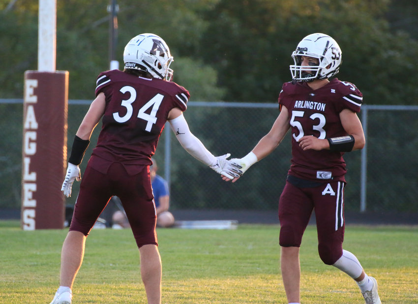 Arlington's Tim Halley (34) and Braden Monke exchange fives after an incompletion defended by Halley.