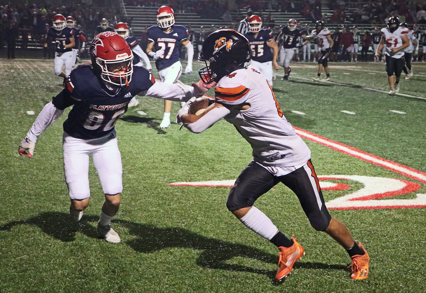 Fort Calhoun freshman Blake Welchert carries the ball against Peyton Matthies, left, and the Trojans on Friday at Platteview High School.