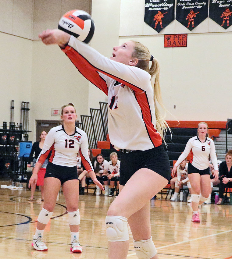 Pioneers senior Olivia Quinlan, middle, sends the ball over her head and the net Monday as Abbey Lienemann, left, and Raegen Wells watch at Fort Calhoun High School. The Pioneers beat the Arlington Eagles, 3-0, during the first round of the Nebraska Capitol Conference Tournament.
