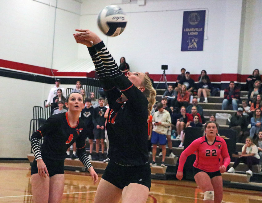 Fort Calhoun senior Olivia Quinlan, middle, hits the ball over her head as Grace Genoways, left, and Mollie Dierks watch Monday during a subdistrict tournament match at Douglas County West High School.