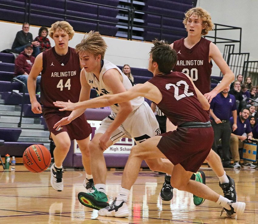 The Bears' Greyson Kay, middle, dribbles the ball by the defense of Arlington's Weston Wollberg, from left, Darren Olson and Trent Koger on Monday at Blair High School.