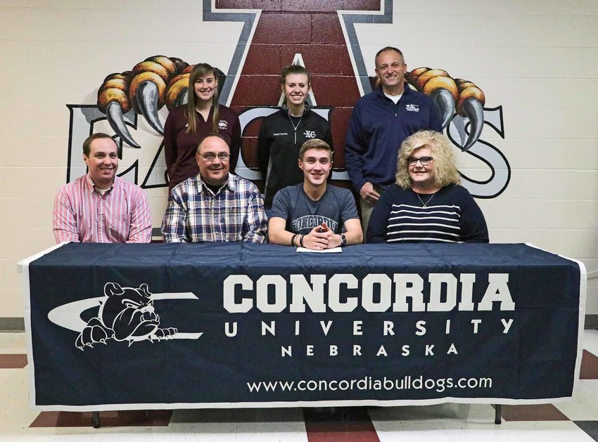Arlington High School senior Luke Hammang, front row, third from left, was joined by family and his coaches Monday as he signed with the Concordia University athletics department.