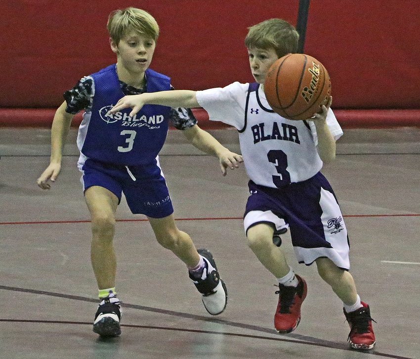 Blair fourth-grader Augie Drew, right, drives to the basket Saturday at Gardner-Hawks Center.
