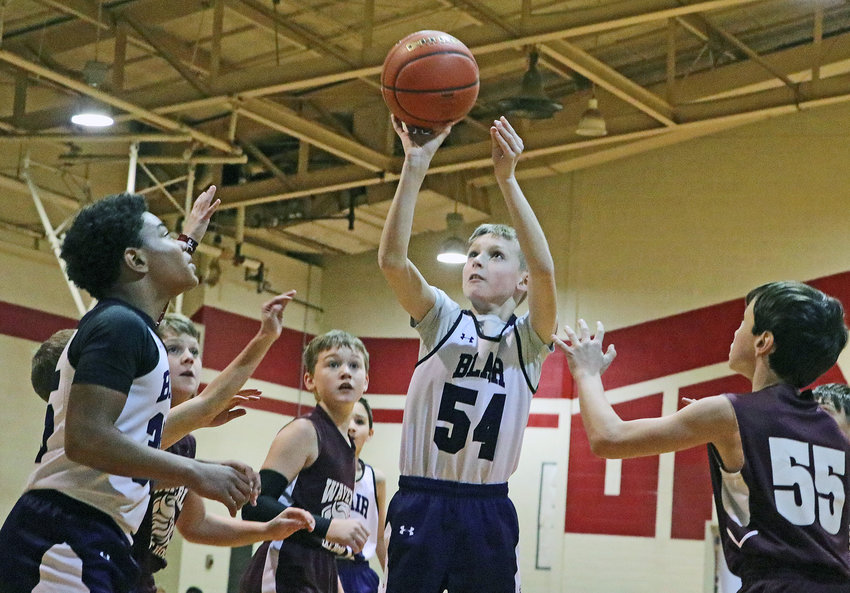 Blair fifth-grader Noah Burnham, middle, shoots in the lane Saturday at Gardner-Hawks Center.